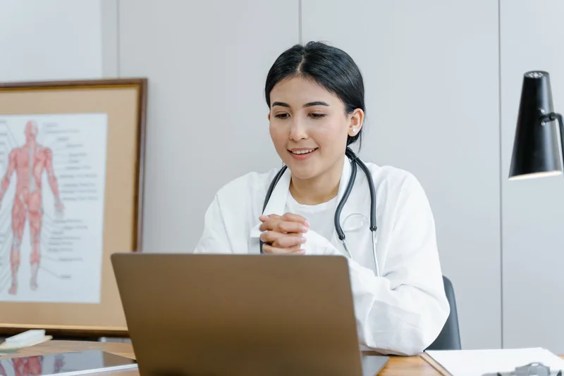 Professionnelle de santé souriante lors d’une consultation, photographie d’illustration médicale civile