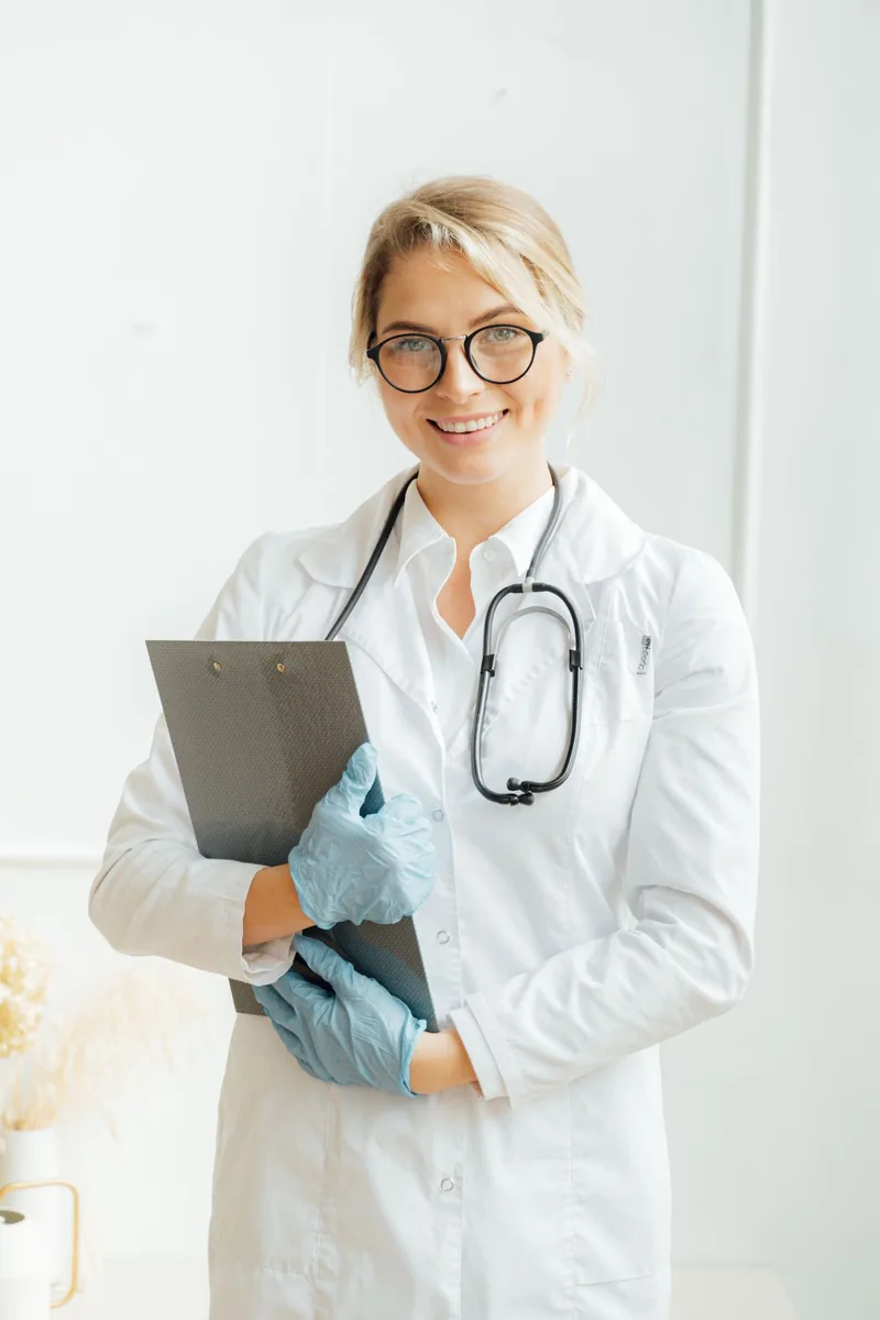 Professionnelle de santé souriante avec un dossier, photographie d’illustration médicale civile